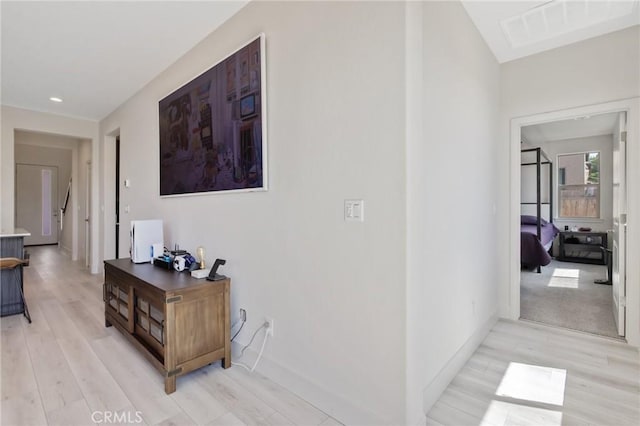 hallway with baseboards, light wood-style floors, visible vents, and recessed lighting