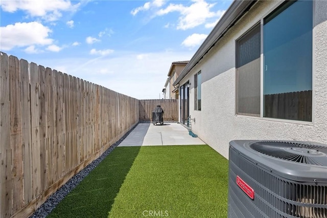 view of yard with central air condition unit, a patio, and a fenced backyard