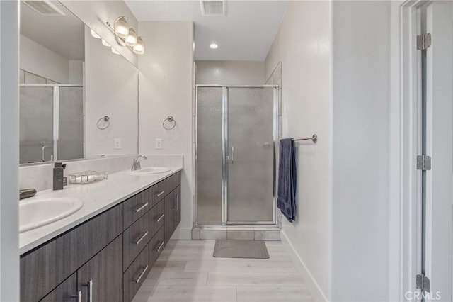 bathroom featuring a shower stall, visible vents, and a sink