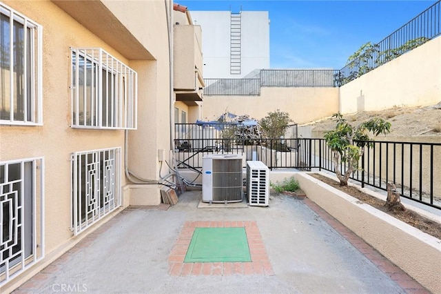 view of patio featuring central air condition unit and fence