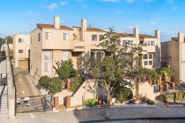 view of property with fence, stairs, and a residential view