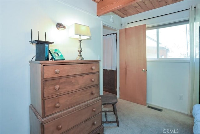 bedroom with beamed ceiling, visible vents, and carpet floors
