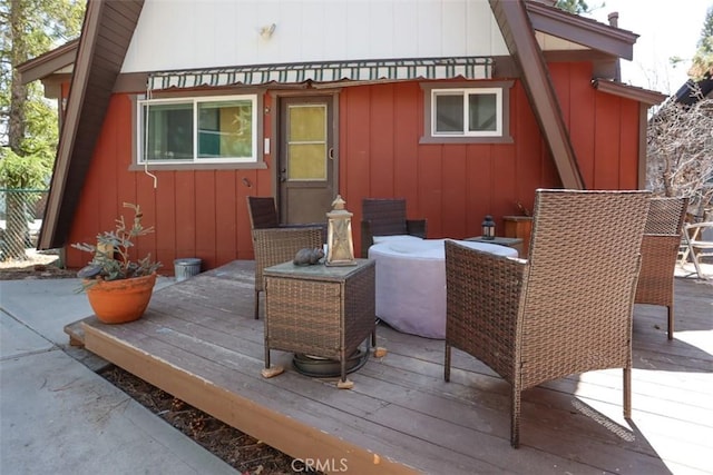 rear view of property featuring a wooden deck and board and batten siding