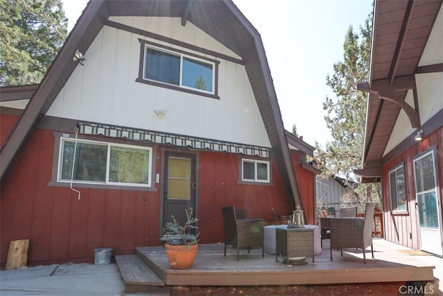 back of house featuring a gambrel roof and a deck