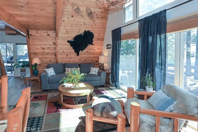 living room with beamed ceiling, a high ceiling, wood walls, and wood ceiling