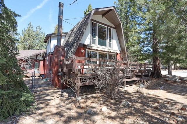 view of front of property featuring a gate, a gambrel roof, and a deck