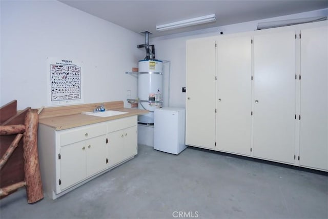 interior space featuring refrigerator, strapped water heater, and a sink