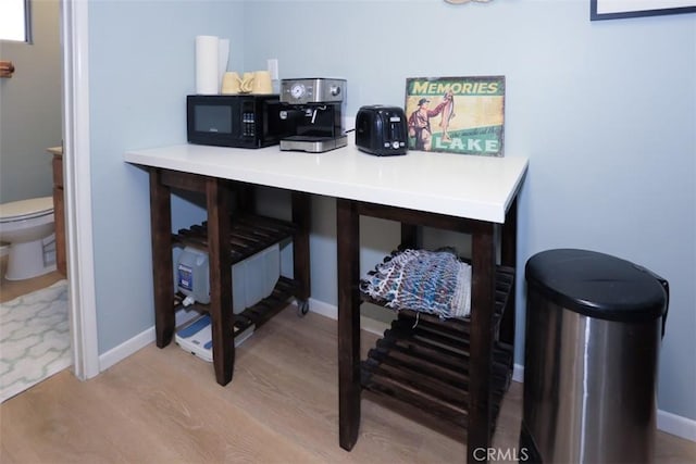 office space with baseboards and wood finished floors