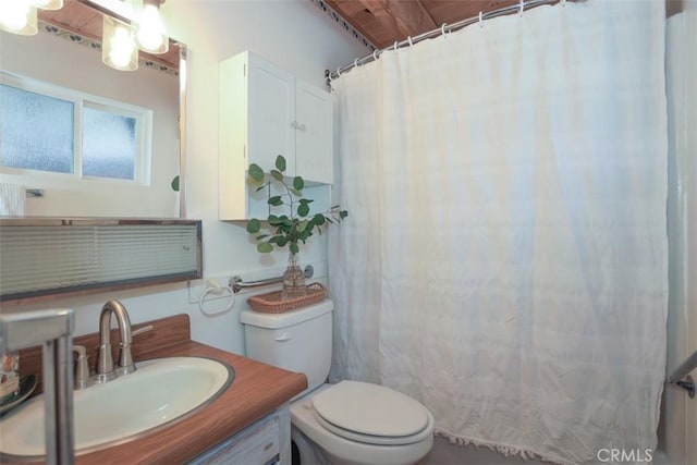 bathroom with toilet, vanity, and a shower with shower curtain