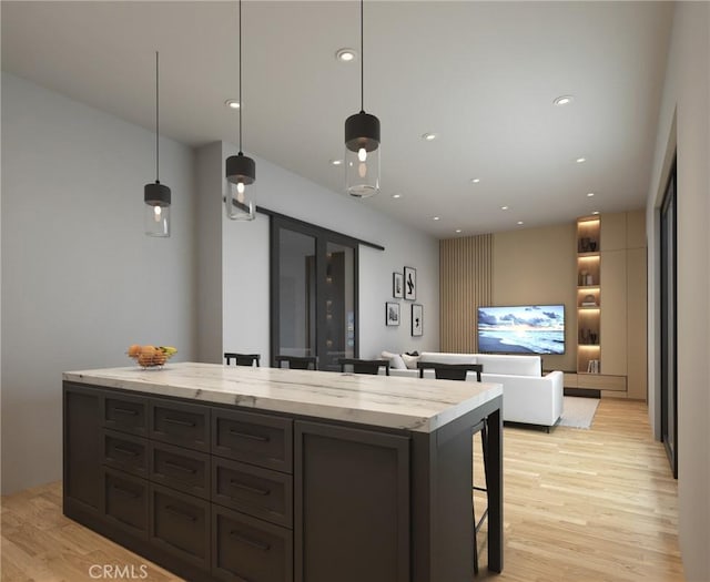 kitchen featuring a center island, a kitchen breakfast bar, light stone countertops, and light wood-style floors