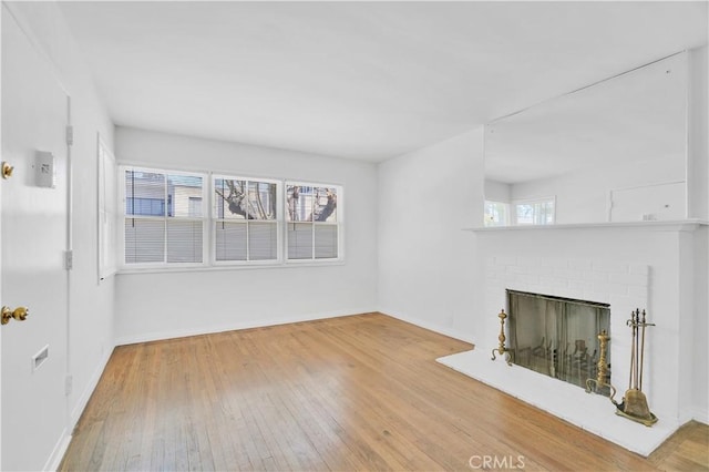 2935 Westwood Blvd, West Los Angeles, CA 90064 - unfurnished living room featuring hardwood / wood-style flooring, baseboards, and a brick fireplace