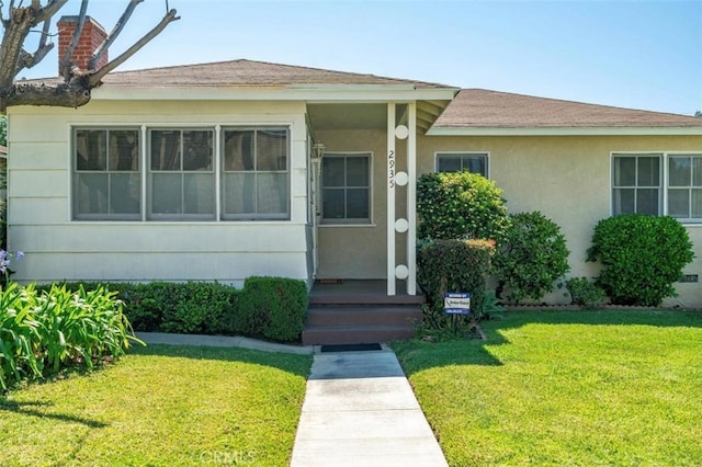 2935 Westwood Blvd, West Los Angeles, CA 90064 - view of front facade with a shingled roof, a chimney, a front yard, and stucco siding