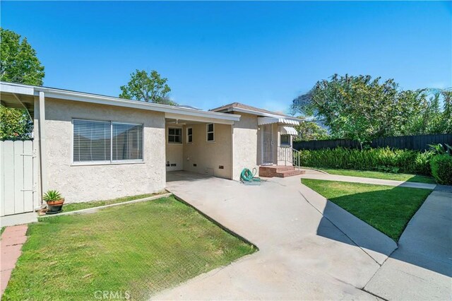 2935 Westwood Blvd, West Los Angeles, CA 90064 - rear view of property featuring a lawn, a patio, stucco siding, and fence