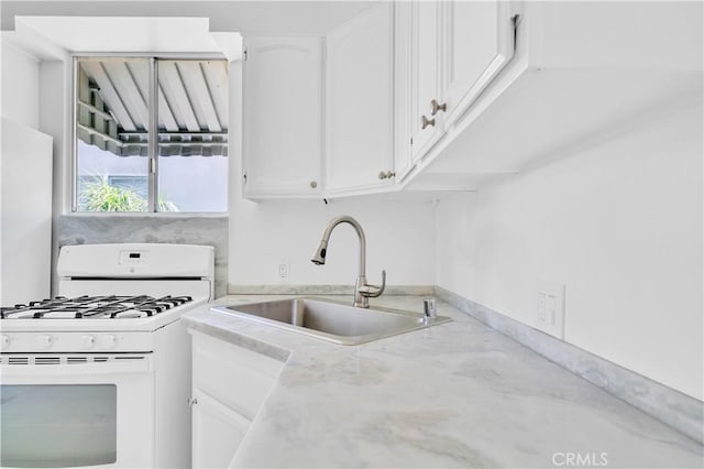 2935 Westwood Blvd, West Los Angeles, CA 90064 - kitchen featuring white cabinets, white gas range oven, and a sink