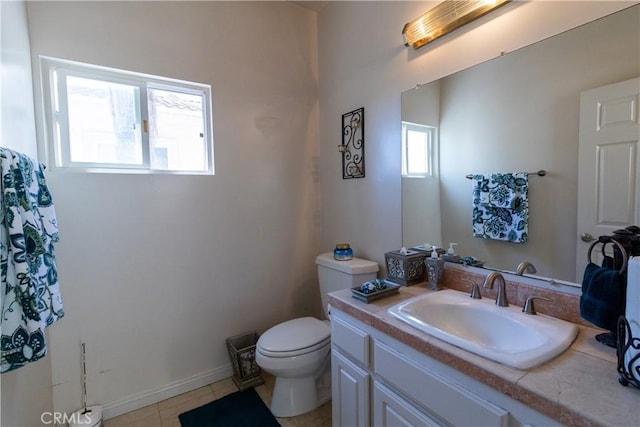bathroom with toilet, tile patterned floors, baseboards, and vanity