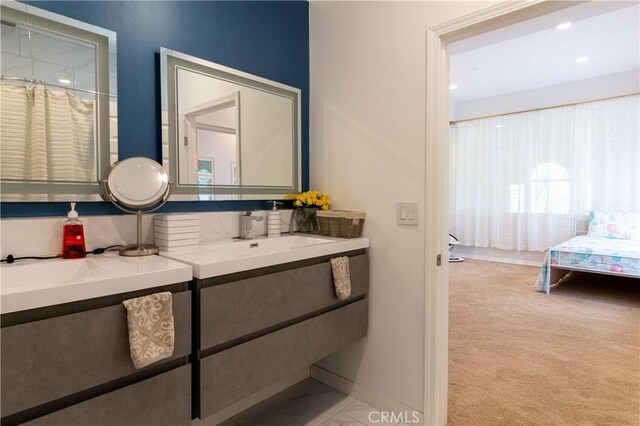 ensuite bathroom featuring vanity, baseboards, ensuite bathroom, and recessed lighting