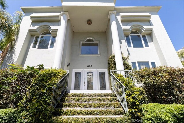 doorway to property featuring stucco siding
