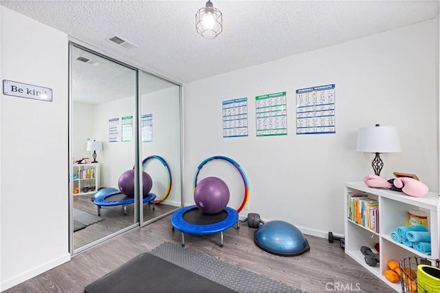 5879 Portsmouth Rd Unit 250, Yorba Linda, CA 92887 - workout room featuring baseboards, wood finished floors, visible vents, and a textured ceiling