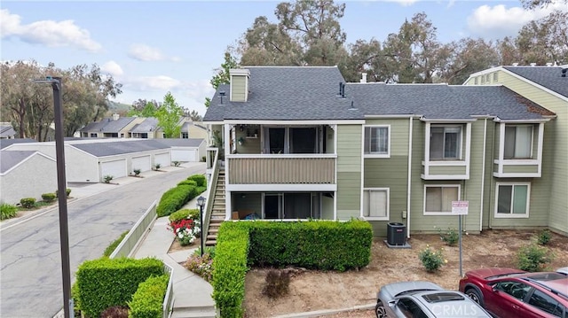 5879 Portsmouth Rd Unit 250, Yorba Linda, CA 92887 - view of building exterior featuring central AC, stairway, a residential view, and uncovered parking
