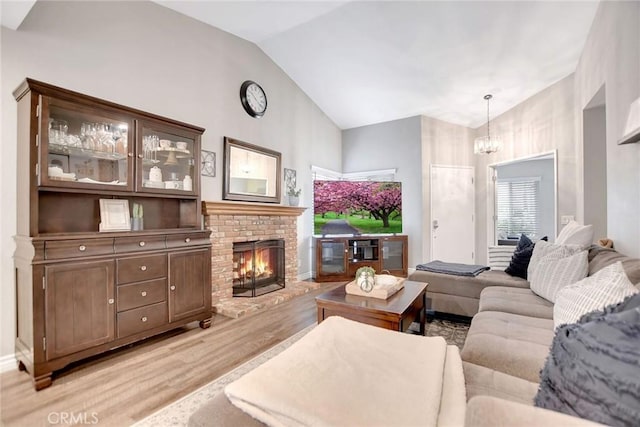 10830 Sundance Dr, Rancho Cucamonga, CA 91730 - living room with light wood finished floors, vaulted ceiling, a fireplace, and a notable chandelier