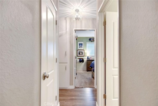 10830 Sundance Dr, Rancho Cucamonga, CA 91730 - hallway featuring a textured wall, a notable chandelier, and wood finished floors