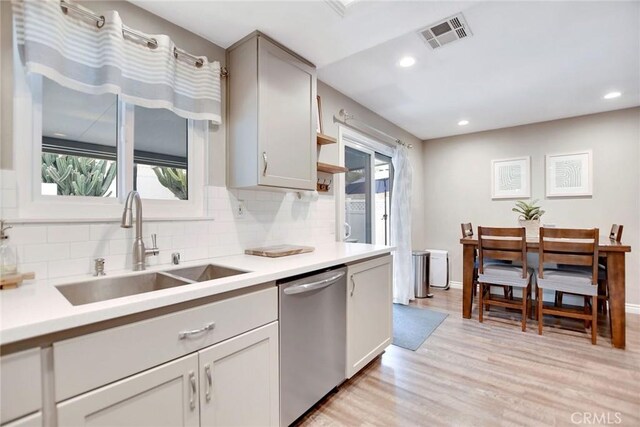 10830 Sundance Dr, Rancho Cucamonga, CA 91730 - kitchen featuring a sink, dishwasher, light wood finished floors, backsplash, and visible vents