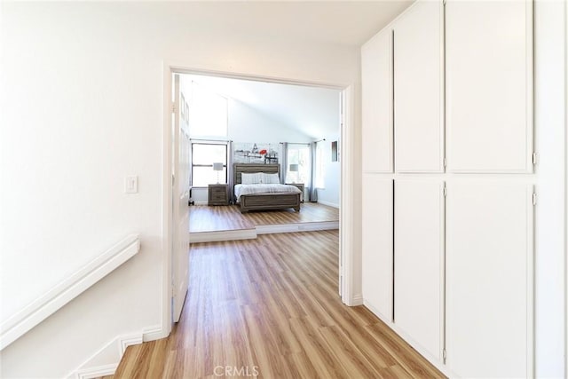 8288 Mercury Dr, Buena Park, CA 90620 - corridor featuring light wood finished floors, vaulted ceiling, and baseboards