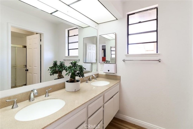 8288 Mercury Dr, Buena Park, CA 90620 - full bath with double vanity, baseboards, an enclosed shower, and wood finished floors
