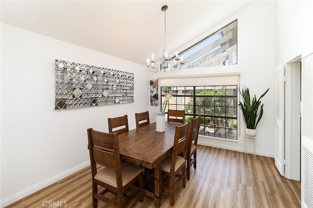 8288 Mercury Dr, Buena Park, CA 90620 - dining room with a chandelier, light wood-style flooring, high vaulted ceiling, and baseboards