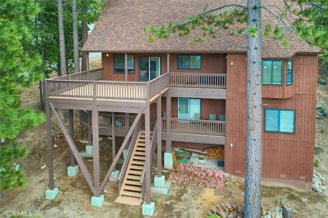 exterior space with stairs and a shingled roof