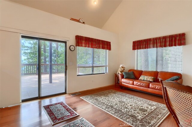 living room with high vaulted ceiling and wood finished floors