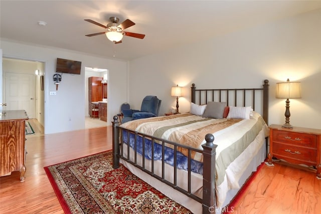 bedroom featuring wood finished floors and ensuite bath