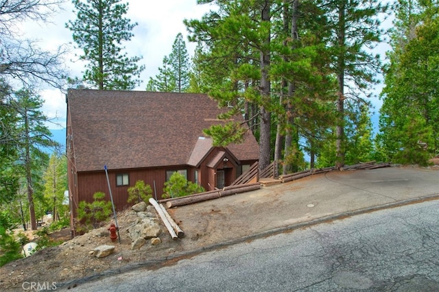 chalet / cabin featuring roof with shingles