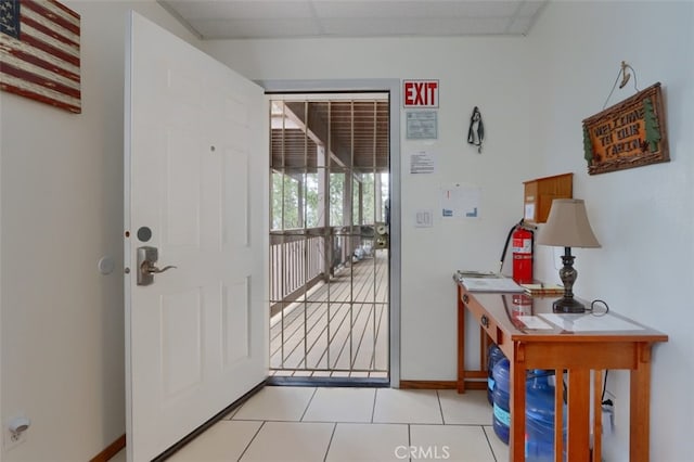 doorway with light tile patterned flooring and baseboards