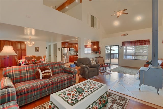 living room featuring light wood finished floors, visible vents, high vaulted ceiling, and ceiling fan with notable chandelier
