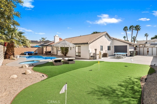 rear view of property featuring a fenced backyard, stucco siding, a patio area, and an in ground hot tub