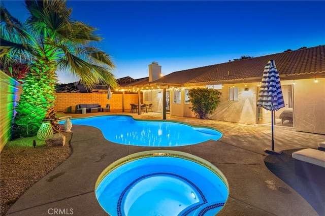 view of pool featuring a patio, a fenced in pool, and an in ground hot tub