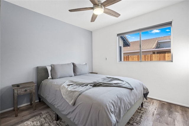 bedroom with wood finished floors, baseboards, and ceiling fan