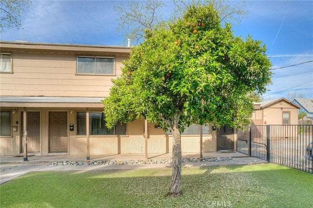 view of front of property featuring fence, a porch, and a front yard