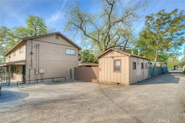 view of property exterior featuring fence and an outbuilding