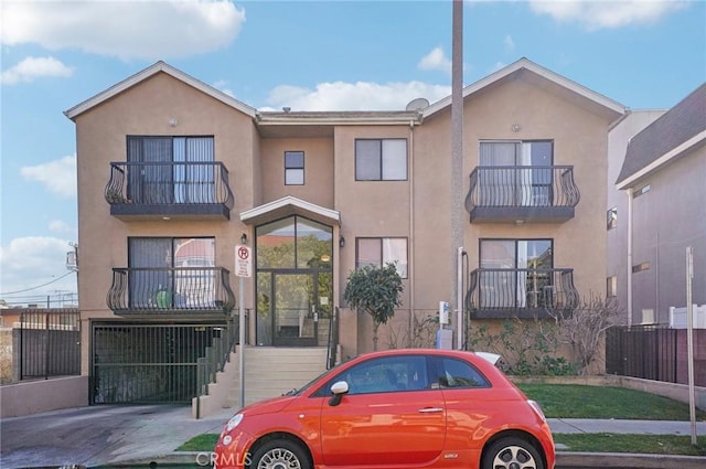 view of property with stucco siding and a balcony
