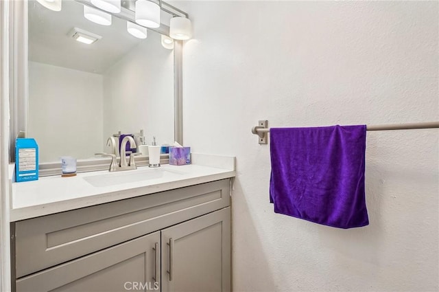 bathroom with a textured wall and vanity