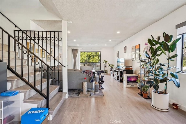 foyer entrance featuring wood finished floors, recessed lighting, a textured ceiling, and stairway