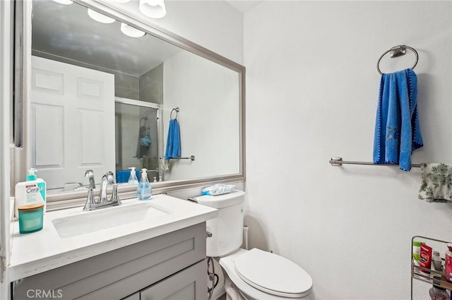 full bathroom with vanity, a shower stall, and toilet