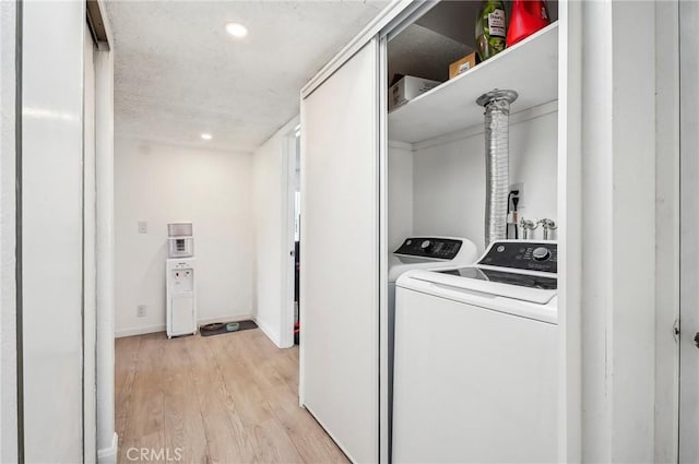 washroom with light wood-type flooring, washing machine and dryer, baseboards, recessed lighting, and laundry area