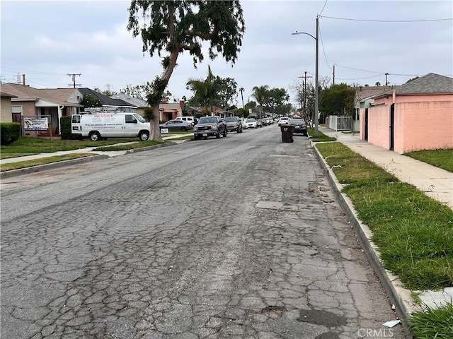 1423 S Poinsettia Ave, Compton, CA 90221 - view of asphalt road with sidewalks, curbs, street lights, and a residential view