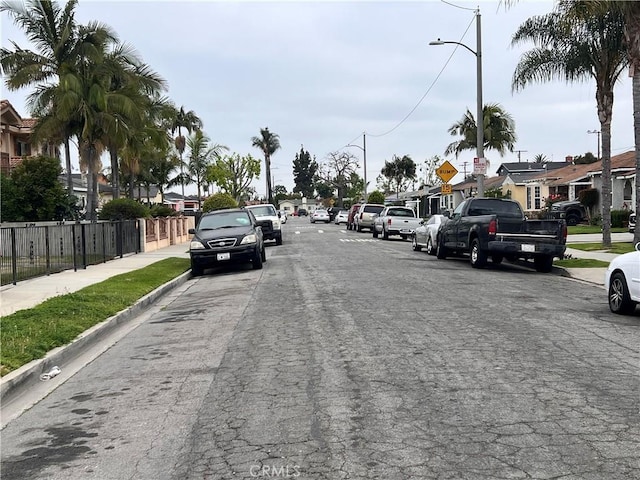 1423 S Poinsettia Ave, Compton, CA 90221 - view of asphalt road with sidewalks, street lighting, curbs, traffic signs, and a residential view