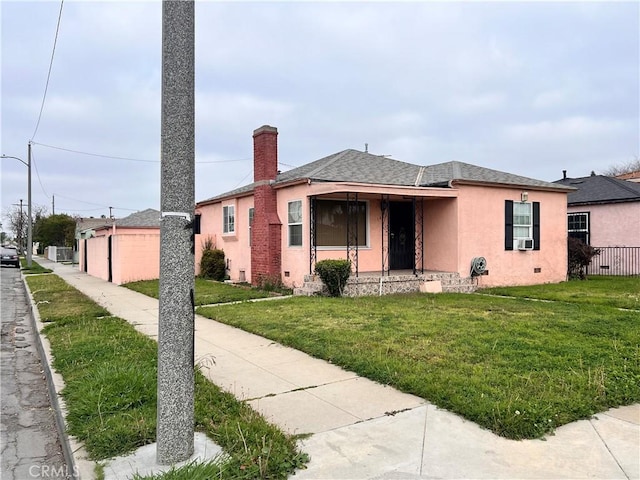 1423 S Poinsettia Ave, Compton, CA 90221 - view of front of property with stucco siding, a front lawn, a shingled roof, and a chimney