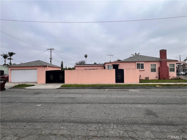 1423 S Poinsettia Ave, Compton, CA 90221 - view of front of home with a garage, stucco siding, fence, and a chimney