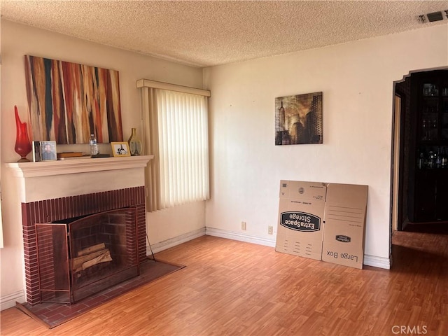 1423 S Poinsettia Ave, Compton, CA 90221 - living room with wood finished floors, a textured ceiling, baseboards, and a fireplace